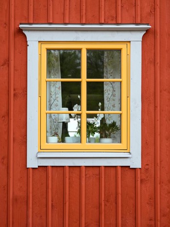 Röd fasad med gult gammaldags fönster